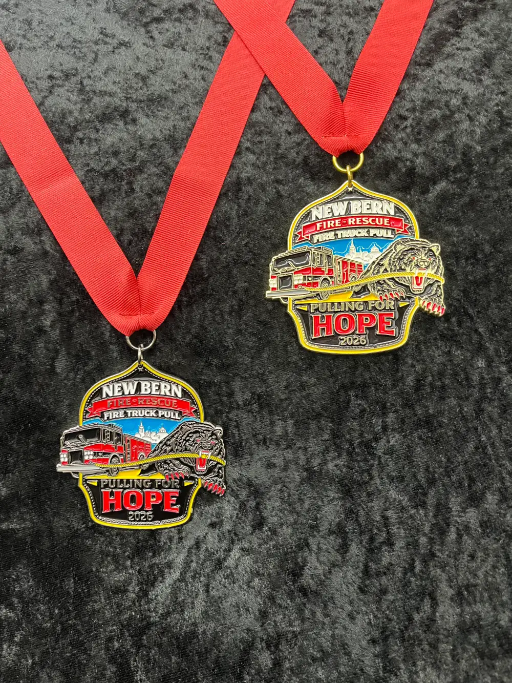 Custom engraved medals featuring colorful truck and bear designs