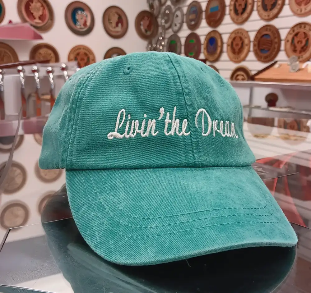 Sea green baseball cap with custom embroidery reading Livin the Dream