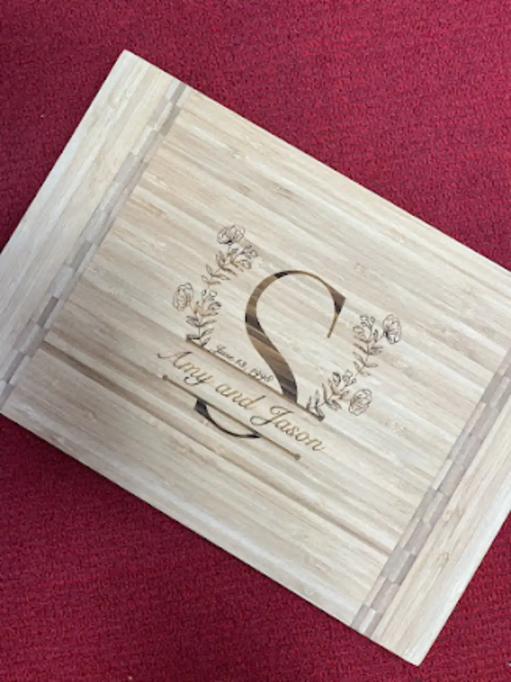 Engraved wood plaque with floral design, large S, and names Amy and Jason